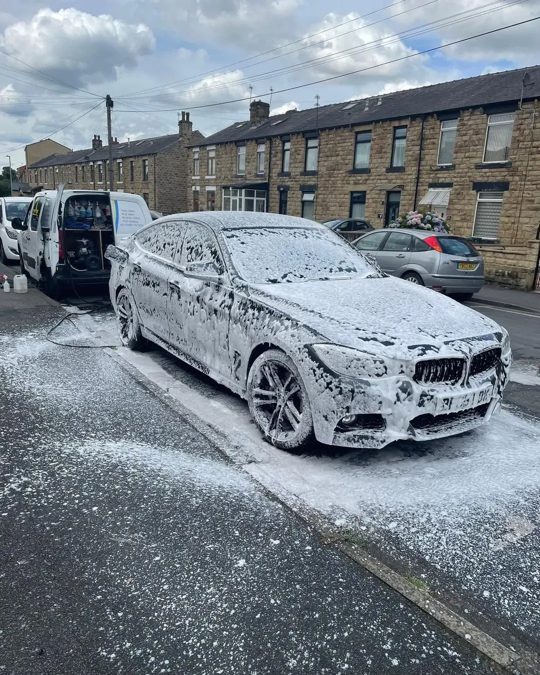 BMW covered in snow foam during an exterior wash